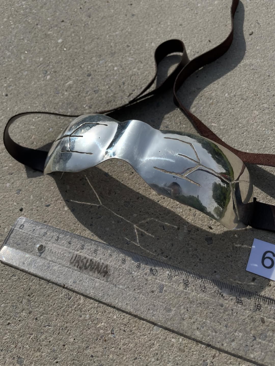 Slit cut silver goggles, three-quarter view showing logo-shaped cuts