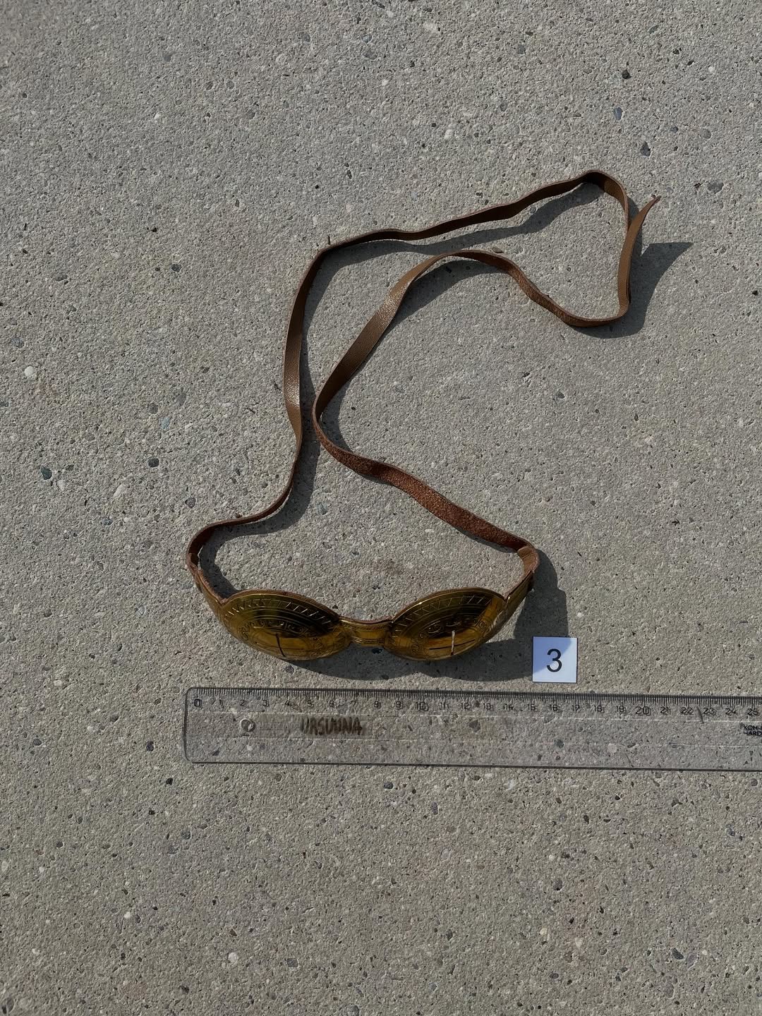 Goggles with full leather strap laid out